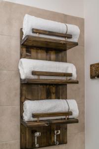 a stack of towels on wooden shelves in a bathroom at Residenza San Gregorio Armeno in Naples