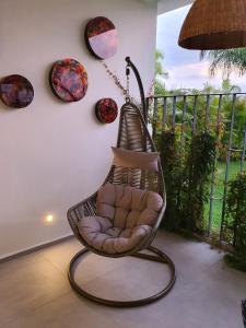 a wicker chair sitting on a porch with plates on the wall at Departamento privado a pie de playa en nuevo vallarta in Bucerías