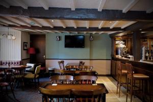 a restaurant with tables and chairs and a flat screen tv at The White Lion Hotel in Machynlleth