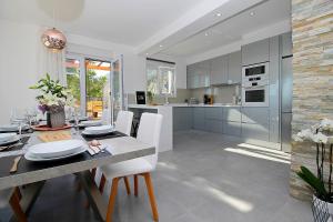 eine Küche und ein Esszimmer mit Tisch und Stühlen in der Unterkunft Villa MIRNA with heated pool & whirlpool, traditional wine bar, 150m from sea in Lokva Rogoznica + 39 Fotos