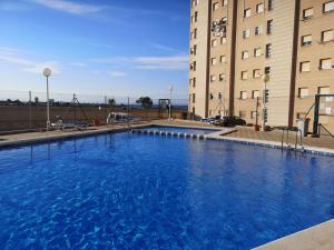 ein großer blauer Swimmingpool vor einem Gebäude in der Unterkunft Apartamento Adan in Playa Honda