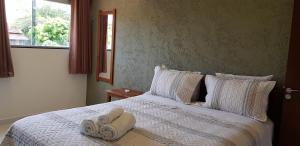 a bedroom with a bed with towels on it at Village São Jorge - Guest Apartment in Sao Jorge