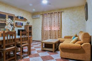 a living room with a couch and a table at Dos casas rurales en Despeñaperros, La Reconquista y Nuevas Poblaciones in Santa Elena