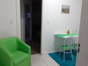 a green chair and a table in a room at Magias da Serra in Canela