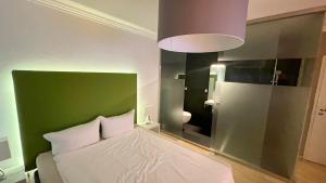 a bedroom with a white bed with a green headboard at smart&beautiful Guesthouse in Nordkirchen