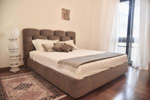 una camera da letto con un grande letto con una grande testiera di Appartamento fronte mare con parcheggio privato a Viareggio