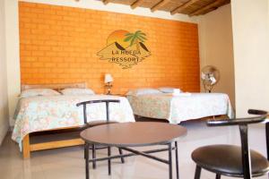 Zimmer mit 2 Betten, einem Tisch und Stühlen in der Unterkunft Hospedaje La Huega in Ica