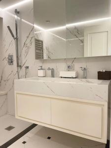 bagno bianco con lavandino e specchio di Appartamento fronte mare con parcheggio privato a Viareggio