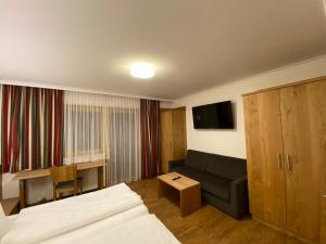 una camera d'albergo con un letto, un divano e un tavolo di Der Brückenhof Ramsau a Ramsau am Dachstein
