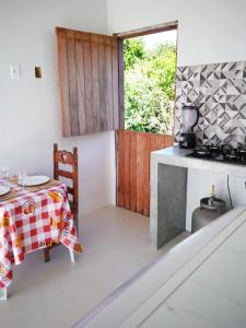 Studio em Arraial في أرايال دو كابو: مطبخ مع طاولة وموقد فرن علوي