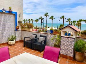 a patio area with chairs, tables, and a balcony at Guadalupe Cozy Inns in Torremolinos