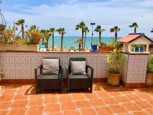 2 sedie su un balcone con vista sull'oceano di Guadalupe Cozy Inns a Torremolinos