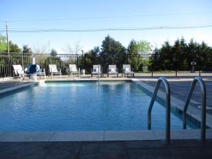 a large swimming pool with chairs and a fence at Best Western Plus McPherson in McPherson