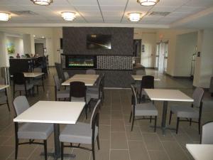 a dining room with tables and chairs and a fireplace at Best Western Plus McPherson in McPherson