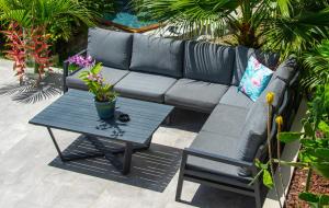 a black couch and a table with flowers on it at Kaz O'Rocher - Sea View Appartements in Le Diamant