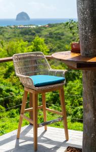 a rattan chair sitting on top of a table at Kaz O'Rocher - Sea View Appartements in Le Diamant