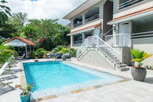 a swimming pool in front of a house at Kaz O'Rocher - Sea View Appartements in Le Diamant +37 photos