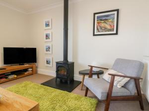 a living room with a chair and a stove at Tremanners in St. Agnes 