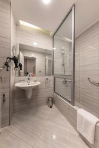 a bathroom with a sink and a shower and a mirror at Royal Day Plaza Hotel in 6th Of October