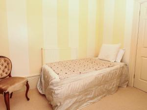 a small bedroom with a bed and a chair at Lion House in Newton Abbot