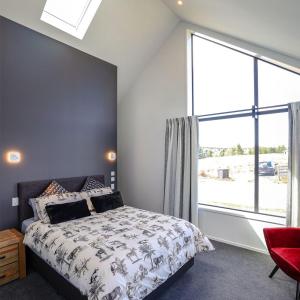 a bedroom with a bed and a large window at The Landsborough Tekapo in Lake Tekapo