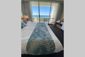 a bedroom with a bed with a view of the ocean at Ocean Bliss - Top floor beachfront studio with amazing views ! in Marcoola