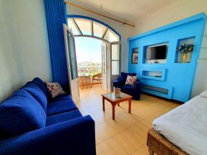 ein blaues Wohnzimmer mit einem Sofa und einem Tisch in der Unterkunft Luxor Guest House in Luxor