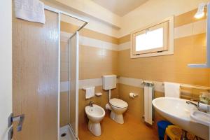 a bathroom with a toilet and a sink and a shower at Villa MiraScopello in Castellammare del Golfo +37 photos