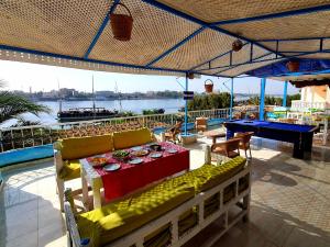 eine Terrasse mit einem Tisch und Blick auf das Wasser in der Unterkunft Luxor Guest House in Luxor