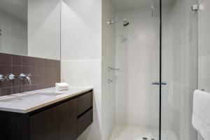 a bathroom with a shower, sink, and toilet at Mantra Hindmarsh Square in Adelaide