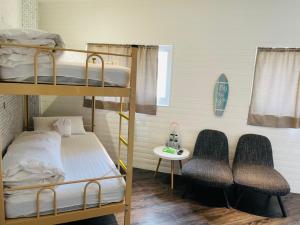 a bunk bed room with two bunk beds and two chairs at King Wow Inn in Tainan