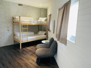 a room with two bunk beds and a chair at King Wow Inn in Tainan