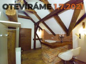 um quarto com vigas de madeira e uma lareira de tijolos em Apartmanový dům 13 Podkroví 1 em Sec