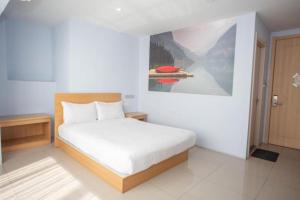 1 dormitorio con 1 cama con una pintura en la pared en 99hotel en Nonthaburi