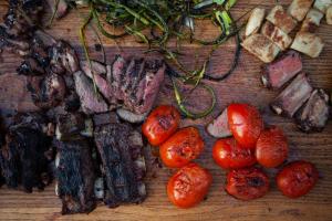 a table with meat and tomatoes and other vegetables at Bodhi Farms in Bozeman