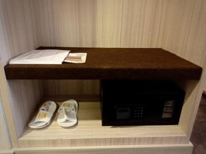 a counter with a pair of shoes and a microwave at Grand Kolopaking Hotel in Kebumen