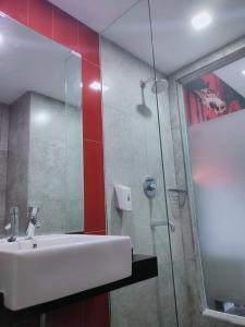 a bathroom with a sink and a glass shower at Grand Kolopaking Hotel in Kebumen