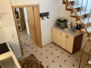 a small kitchen with a staircase and a microwave at EMC Maisonette in Aidlingen