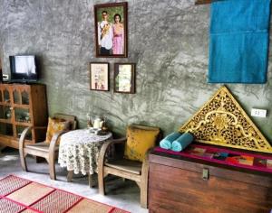 a living room with a table and two chairs and a table sidx sidx at Lanlay Home Stay Krabi in Ao Luk