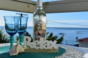 a bottle of wine and two glasses on a table at Moeraki Beach Motels in Moeraki