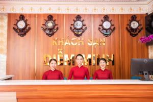 Tres mujeres están detrás de un mostrador con relojes. en Khách Sạn Diễm Minh, en Can Tho