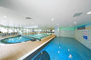 a large swimming pool with blue water in a building at Orakai Insadong Suites in Seoul