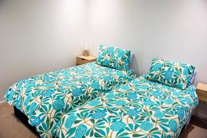 um quarto com uma cama com um edredão azul e branco em Absolute Waterfront - Tropical Aurora Top Floor Over The Water em Darwin