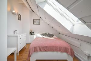 sypialnia na poddaszu z łóżkiem i oknem dachowym w obiekcie Dom Pujszany w mieście Zamość