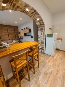 una cucina con tavolo, sedie e frigorifero di TheKeyStudio, TimeToLive with garden view in 1 min from sea a Bordighera Altre 8 foto