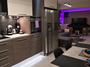 a kitchen with stainless steel appliances and a living room at Luxury Home in Spáta