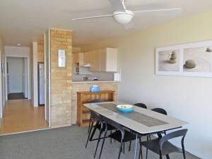 een eetkamer en een keuken met een tafel en stoelen bij Collendina 3 position and water views in Nelson Bay