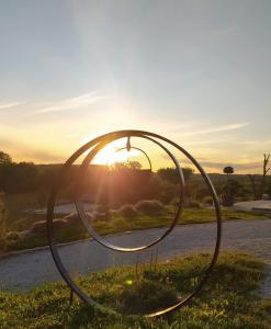 a large metal sculpture with the sunset in the background at GITE LA ROCHE in Le Boulvé