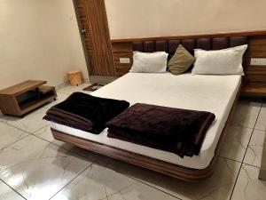 a bedroom with a large bed with brown blankets at Hotel Milan in Ahmedabad