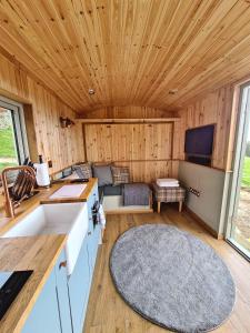 a kitchen and living room with a couch and a television at Peak District Shepherds Hut in Hope